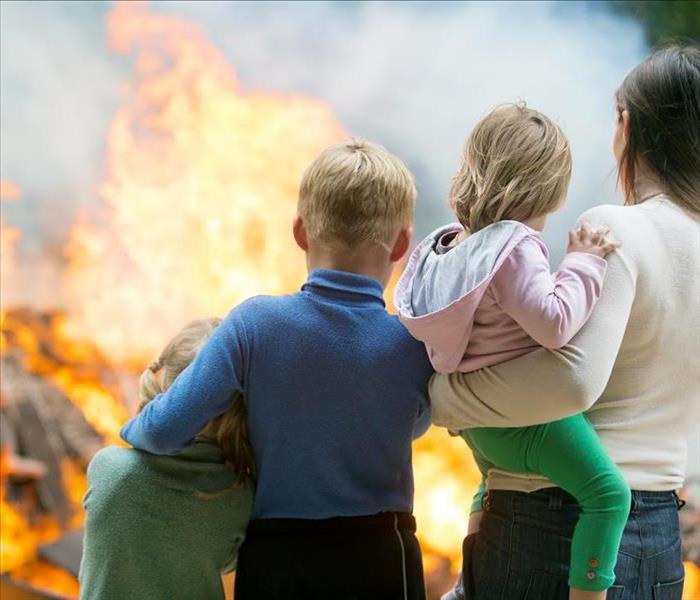 Image of a family watching their home on fire.