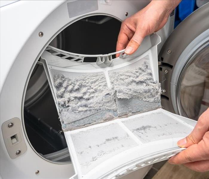 Image of a person cleaning dryer lint