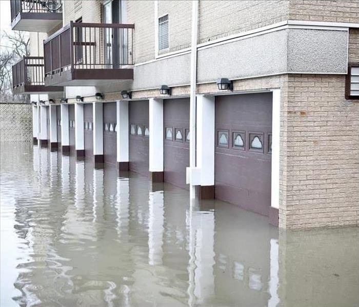 Image of a street flooded causing damage to nearby buildings.