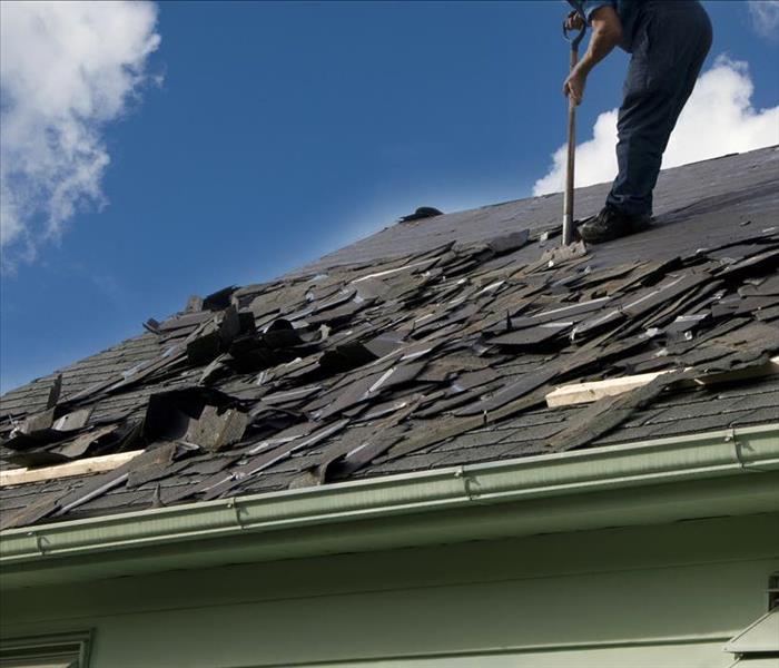 Image of a person repairing a damaged roof